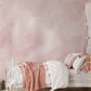 a bedroom with pink walls and a white bed