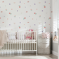 a baby's room with a white crib and a flower wallpaper