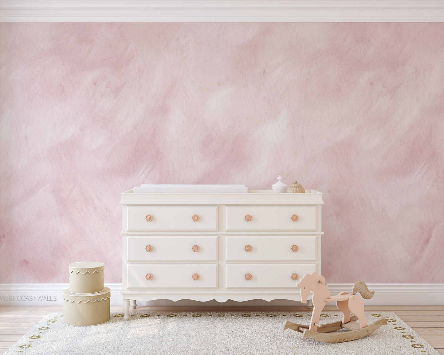 a baby's room with pink walls and a white dresser