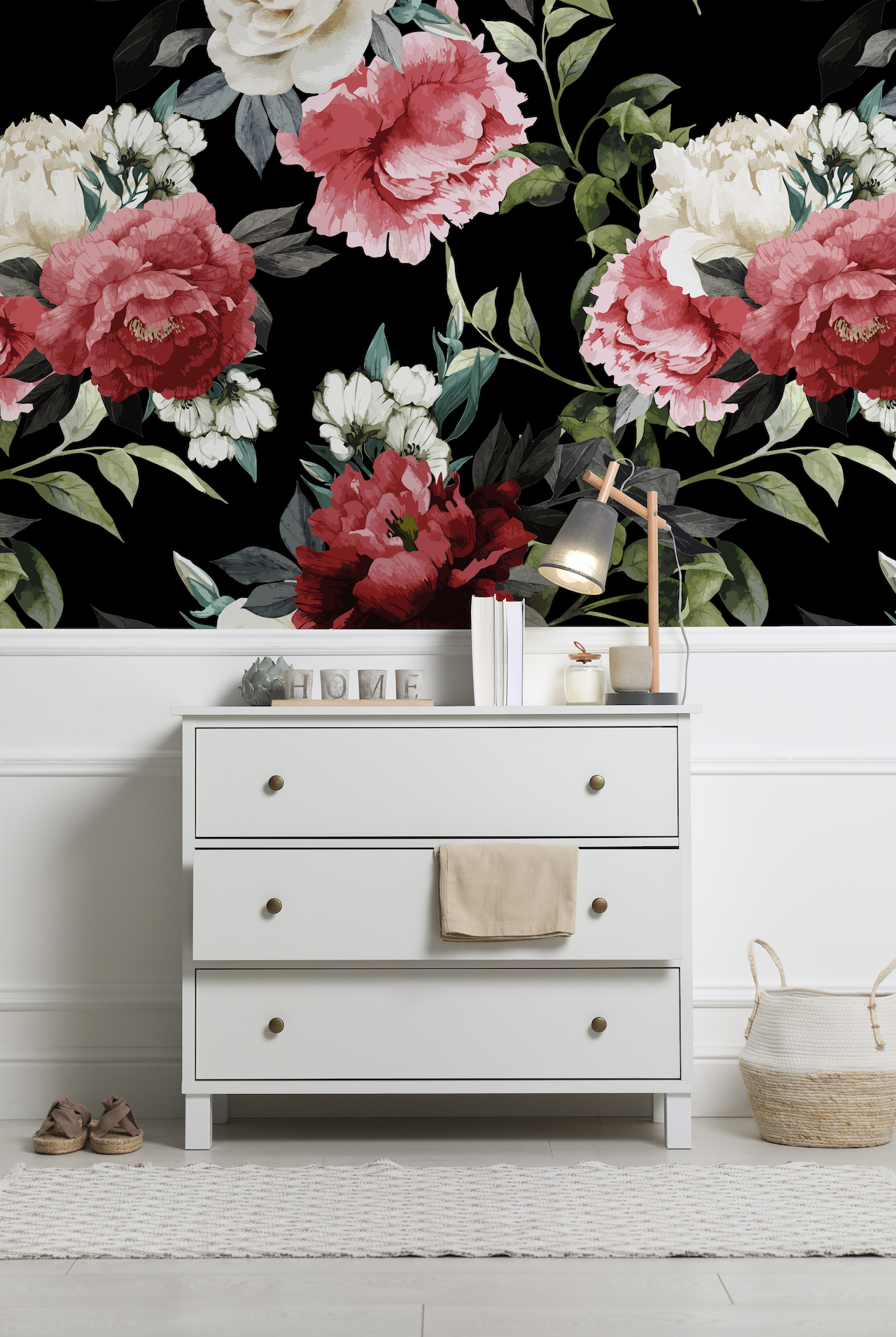 a white dresser sitting next to a wall with flowers on it