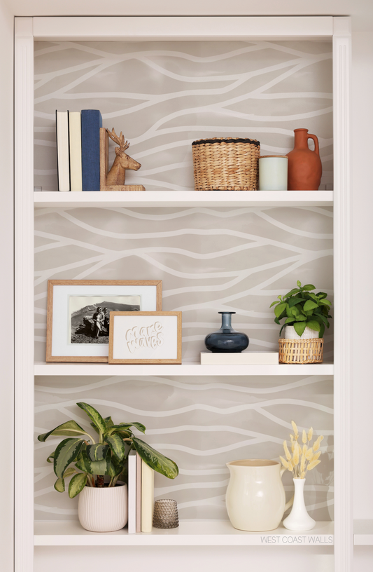 a white book shelf filled with books and plants