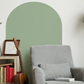 a living room with a gray chair and a green wall